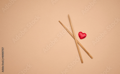two wooden chopsticks on a brown background, copy space © nndanko