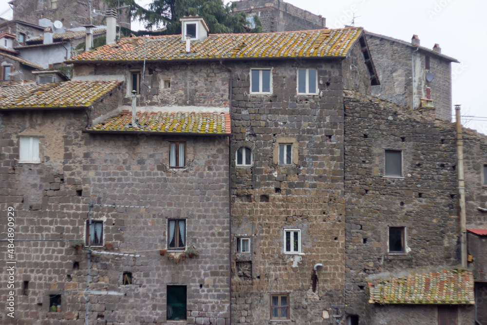 The original structure of building and architectonics(11th-18th century) in The Medieval village of Ronciglione,Italy.Design tuff home with a small window,photography on cloudy day. The original structure of building and architectonics(11th-18th century) in The Medieval village of Ronciglione,Italy.Design tuff home with a small window,photography on cloudy day.