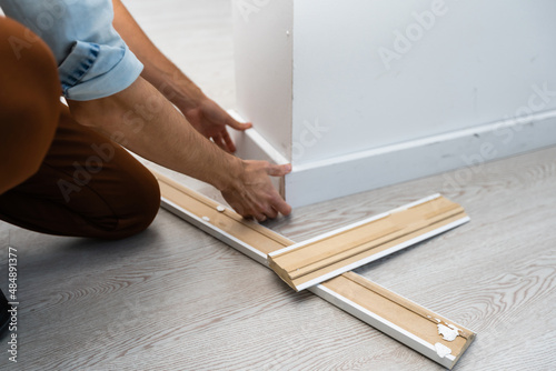 Installing the new skirting board after changing the parquet photo