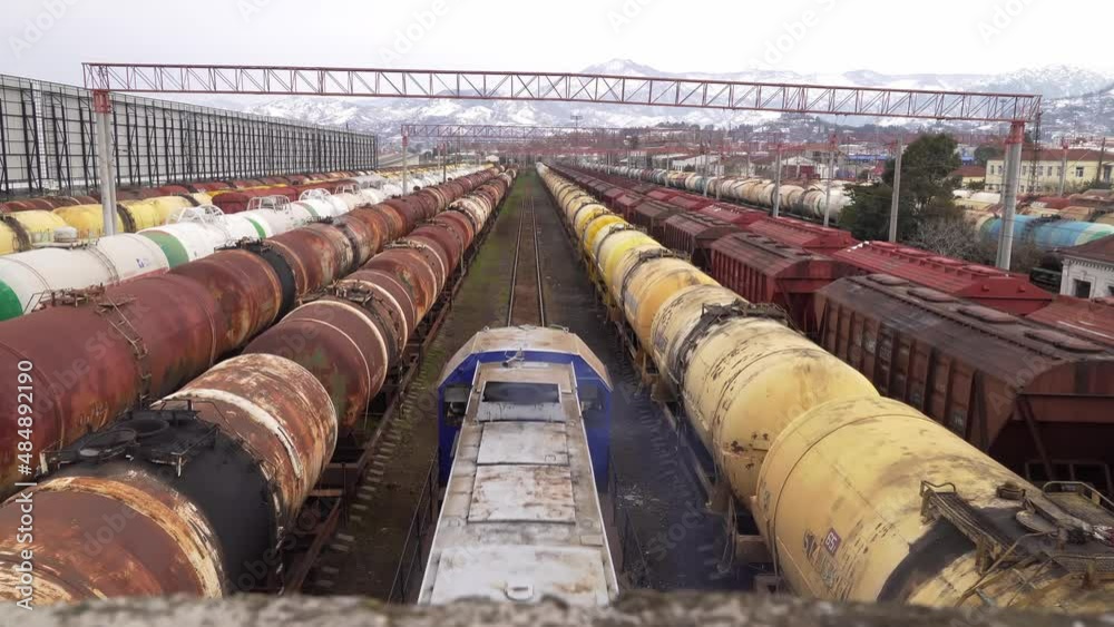Freight trains parked at the railway station. the train is moving. Wagons with cargo. Heavy industry. Industrial conceptual scene with trains. Customs. Against the background of mountains and snow.