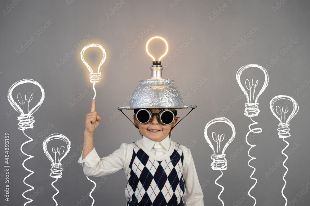 Smart child wearing funny helmet with illuminated lightbulb - obrazy, fototapety, plakaty 