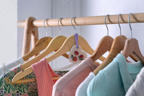 Beautiful scented wax sachet and clothes hanging on wooden rack indoors