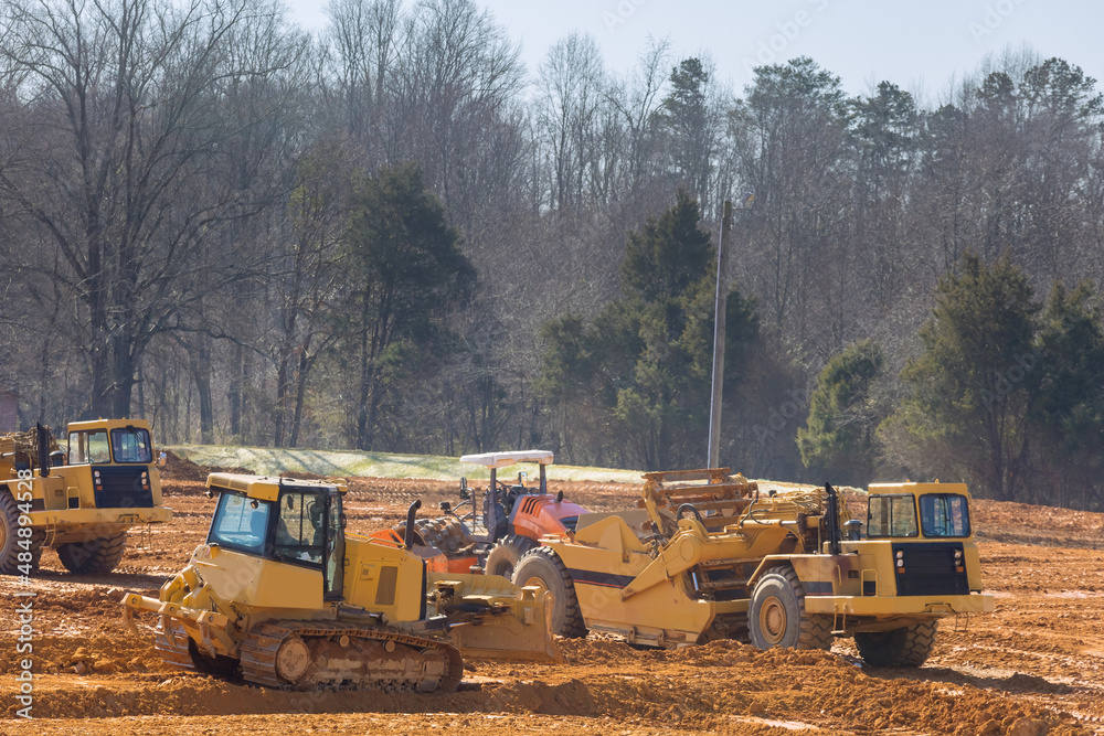 large wheel loader aligns a piece of land for a new building