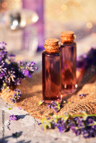 Lavender oil and lavender flowers on bokeh background
