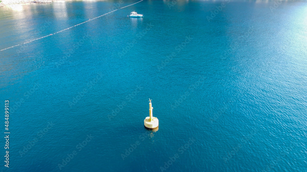 Aerial view of Yellow Sea Buoy in turquoise water of Mediterranean Sea. Marine Navigation Buoy. Safe water mark Aerial view of Yellow Sea Buoy in turquoise water of Mediterranean Sea. Marine Navigation Buoy. Safe water mark