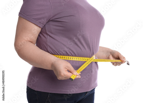 Overweight woman measuring waist with tape on white background, closeup