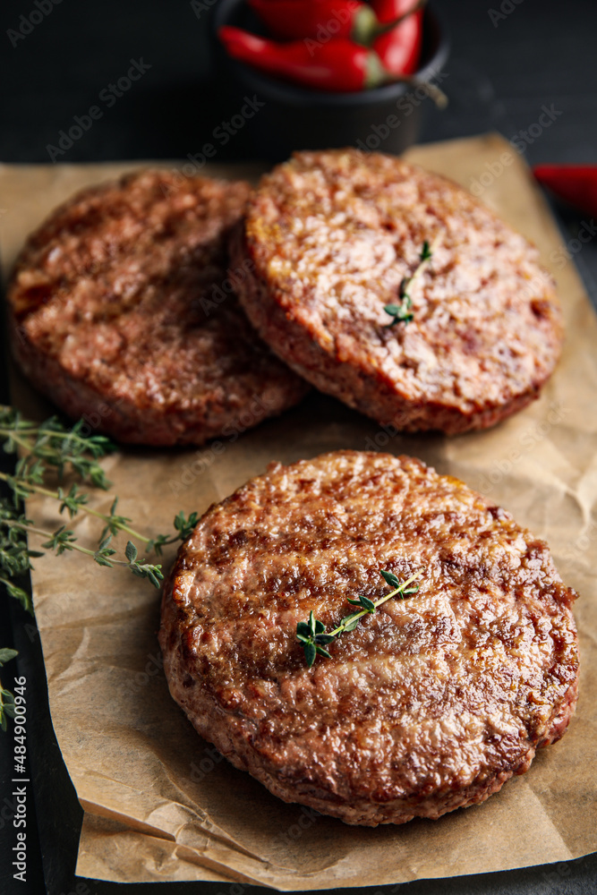 Tasty grilled hamburger patties with thyme on black table, closeup Tasty grilled hamburger patties with thyme on black table, closeup