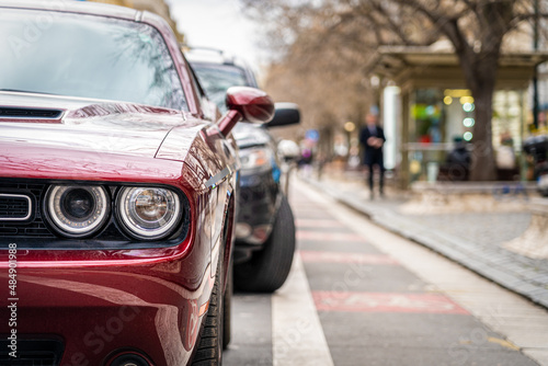 Sport car parked in a row on a city street side.