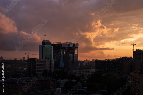 Colorful dramatic sky with clouds at sunset over the urban landscape.
