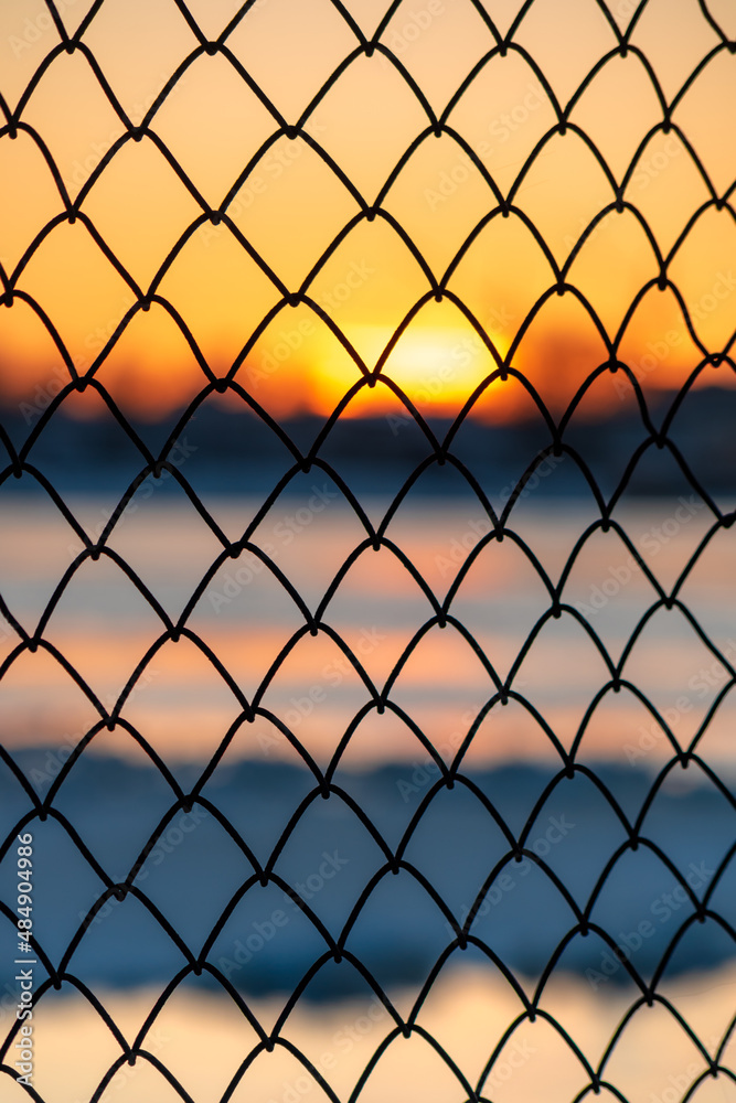Old metal fence with a colorful sunset and Riga city in the background. Andrejosta pier by the harbour. Old metal fence with a colorful sunset and Riga city in the background. Andrejosta pier by the harbour.
