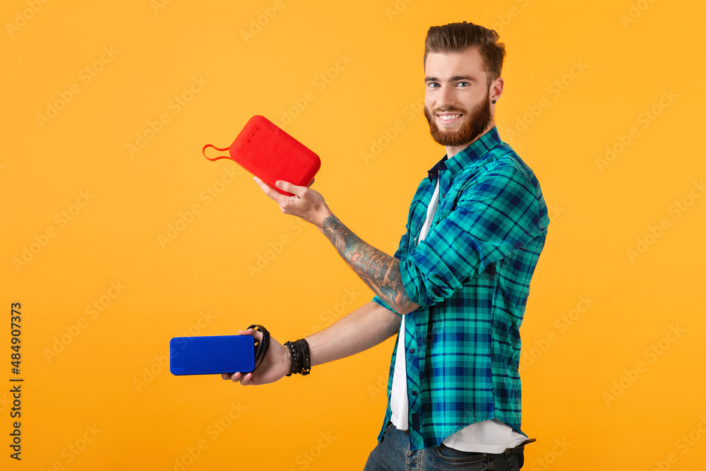 stylish young man holding wireless speakers stylish young man holding wireless speakers