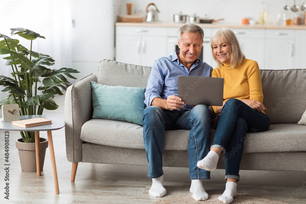 Cheerful Senior Spouses Using Laptop Watching Movie Onilne At Home Cheerful Senior Spouses Using Laptop Watching Movie Onilne At Home
