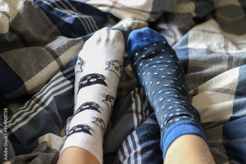 Model using a pair of mismatched socks in bed photo