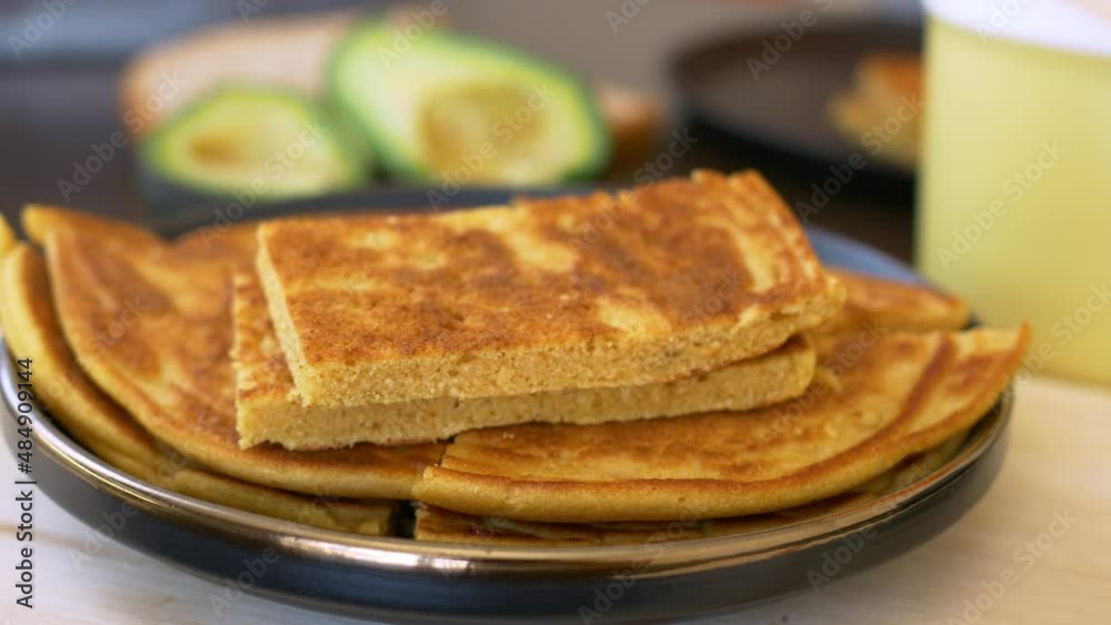 Close-up mom prepares a delicious breakfast, puts fresh hot pancakes on a plate. A hearty breakfast for the whole day a boost of energy. Homemade food concept Close-up mom prepares a delicious breakfast, puts fresh hot pancakes on a plate. A hearty breakfast for the whole day a boost of energy. Homemade food concept