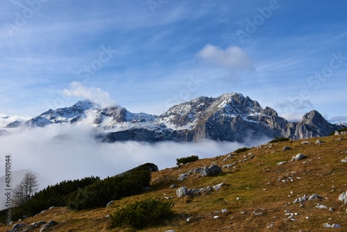 Scenic view of mountains Triglav and Rjavina in Julian alps and Triglav national park, Slovenia with fog bellow the mountain peaks