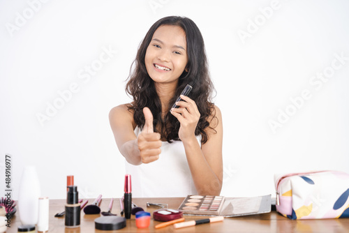 asian young woman with make up showing thumb up gesture