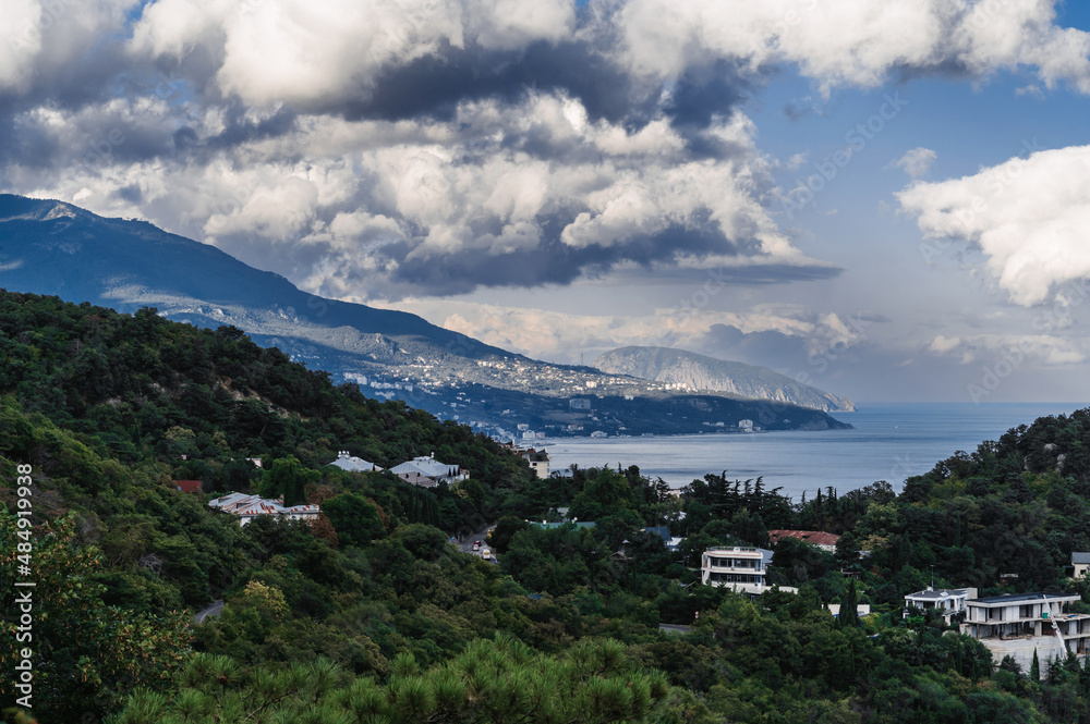 Landscape with a view of the resort town on the seashore on a summer cloudy day Landscape with a view of the resort town on the seashore on a summer cloudy day