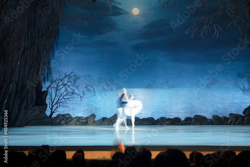 Fototapeta Naklejka Na Ścianę i Meble -  Classical ballet on stage of Theater. Ballet dancers on stage dance classical works. Form of artistic ball dance on stage of theater.