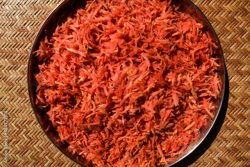 Fresh grated carrot vegetable preparation to make carrot recipes like gajar ka halwa. Grated carrot in plate dish photo