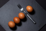 Chicken eggs on a black surface. Nutritious and delicious breakfast. Beautiful food presentation