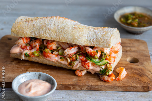 Stonebaked baquette with crayfish, pickled cucumbers, spicy dressing and sriracha mayonnaise photo