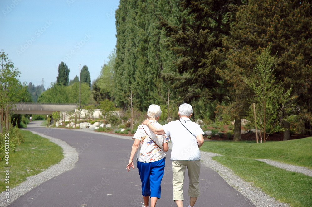 Lesbian female seniors walking on a trail outside. Lesbian female seniors walking on a trail outside.