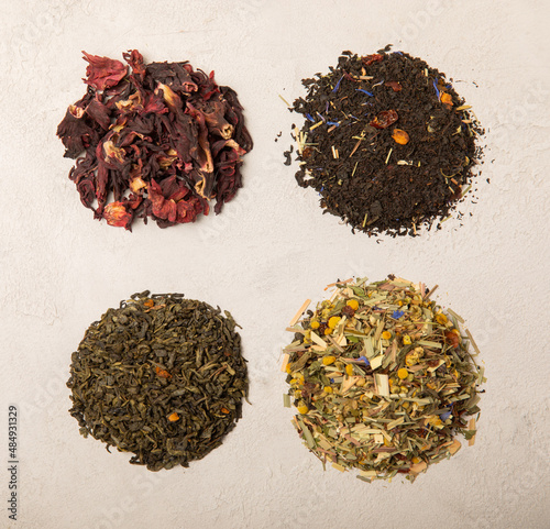 set of different types of tea on a light background.Herbal, green,black and hibiscus tea.Top view.Copy space. Flat lay.Tea mix.