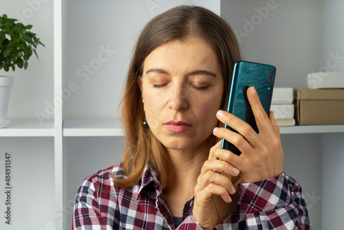 Fototapet Blind woman holding mobile phone using speakerphone.