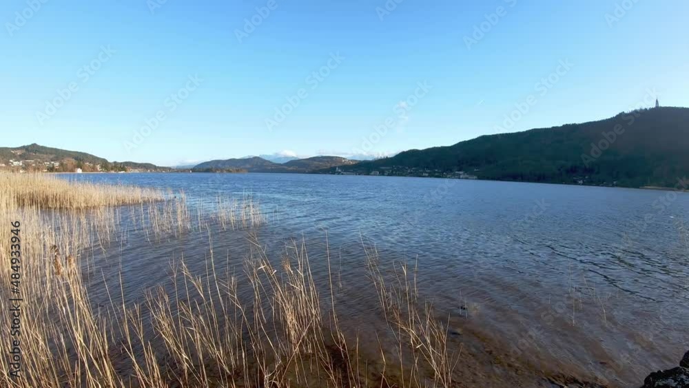A panoramic view on the calm surface of the Woerthersee Lake in Austria.The lake is surrounded by high mountains.Small villages at the shores, and a small water park with slides.Timelapse
A panoramic view on the calm surface of the Woerthersee Lake in Austria.The lake is surrounded by high mountains.Small villages at the shores, and a small water park with slides.Timelapse