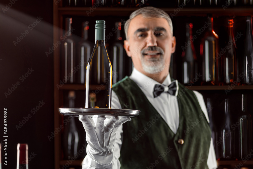 Sommelier wine steward with a bottle of wine. Examination of wine