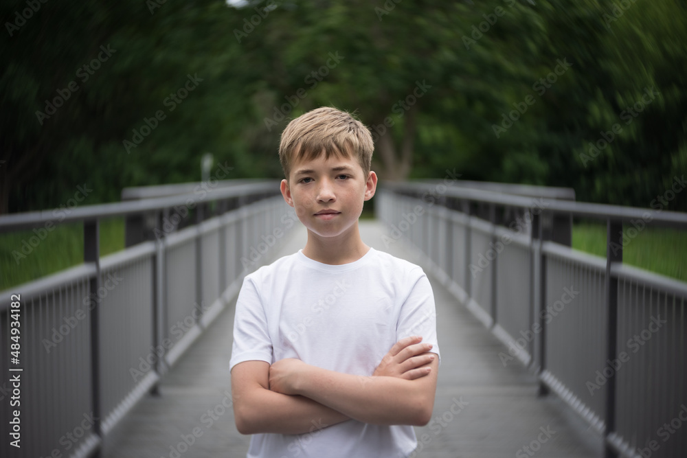 Portrait of a teenager standing on a bridge.