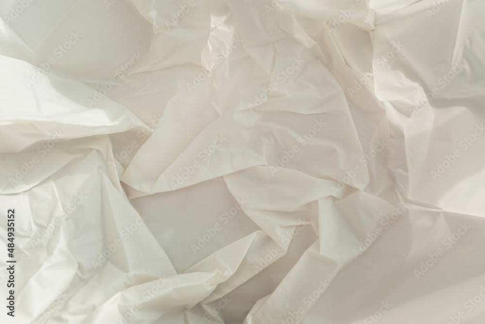 Crumpled craft white paper with hard shadows. Close up background. Crumpled craft white paper with hard shadows. Close up background.