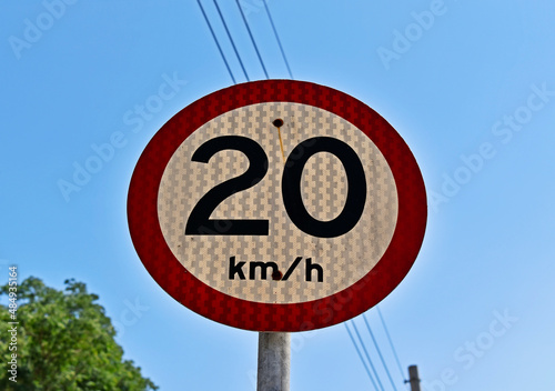 Traffic sign speed limit at 20 kilometers per hour on a street photo
