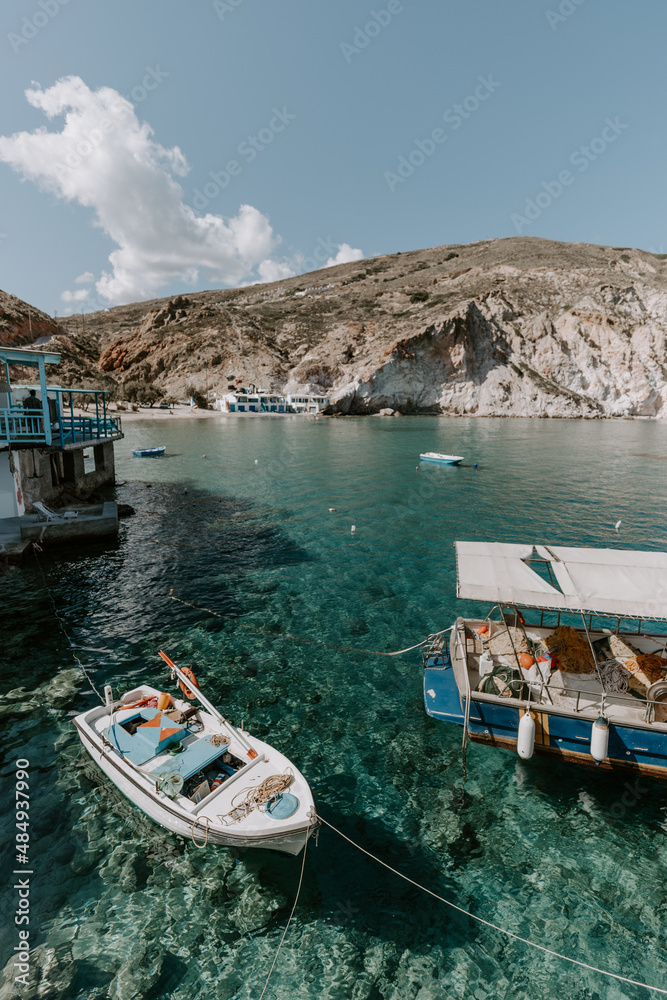 Idyllic landscapes of tourist destination- Milos Island in Greece. The photo shows colourful fisherman houses, turquoise waters of Aegean Sea captured on a sunny hot day during holidays 