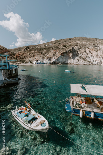 Idyllic landscapes of tourist destination- Milos Island in Greece. The photo shows colourful fisherman houses, turquoise waters of Aegean Sea captured on a sunny hot day during holidays 