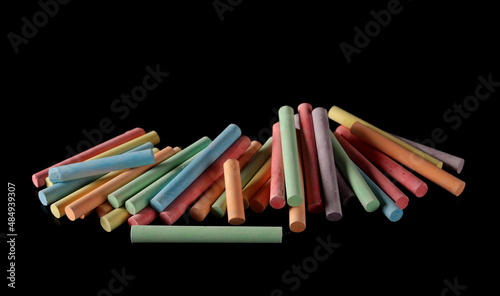 Colorful chalks pile isolated on black 