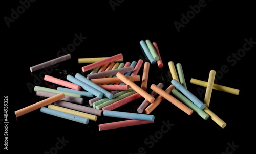 Colorful chalks pile isolated on black 