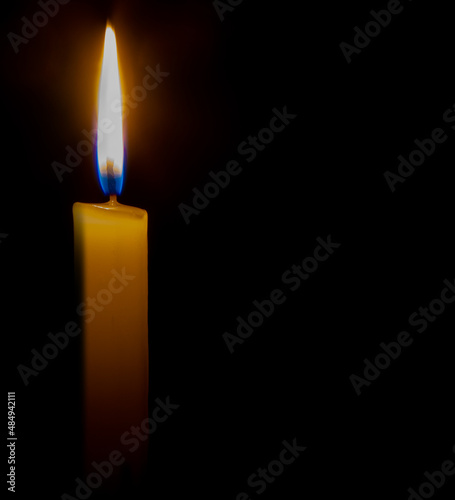close-up candle. female hands lit the flame of a candle on the day of memory and sorrow.