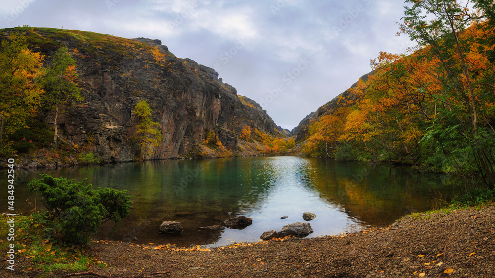 Emerald lake in the Khibiny mountains. Lake with emerald water with rocky shores. Emerald lake in the Khibiny mountains. Lake with emerald water with rocky shores.