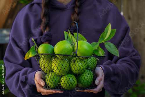 Girl Holding Basket of Limes