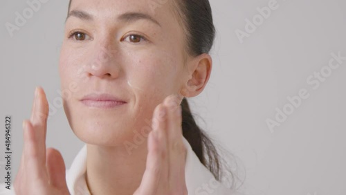 Close Up Shot of a Woman Rubbing Cream on Her Face
