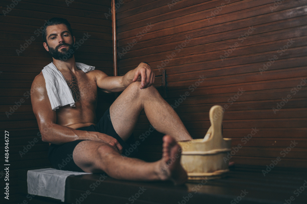 custom made wallpaper toronto digitalBeautiful healthy boy relaxing in a wooden sauna. Young bearded man resting after workout in the gym. Fitness male with tattoo and white towel, laying on the bench in the spa. Wellness, health concept