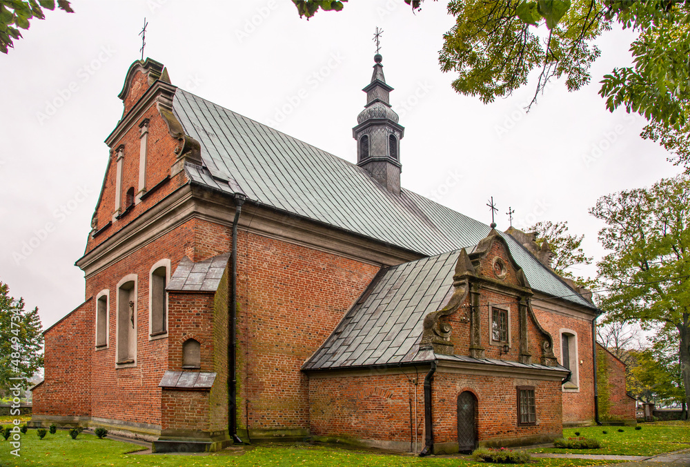 Naklejka premium Built in the years 1477-1507 in the Gothic and Neo-Baroque styles, the historic Catholic Church of Our Lady of the Rosary with a belfry in the city of Drobin in Mazovia, Poland.