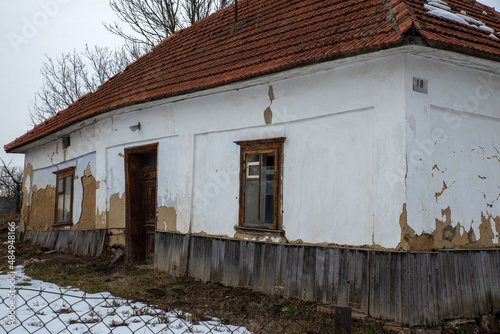 Destroyed and ruined house with red ceramic tiles, abandoned in the village