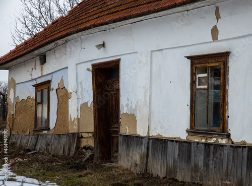 Destroyed and ruined house with red ceramic tiles, abandoned in the village