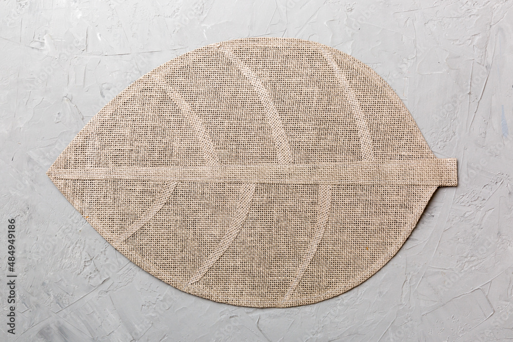 Obraz premium Perspective view of leaf shaped tablecloth for food on cement background. Empty space for your design.