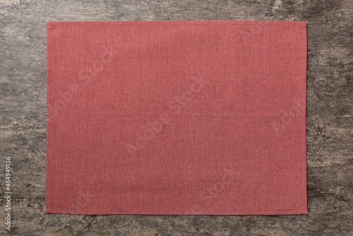 Top view of red tablecloth for food on cement background. Empty space for your design