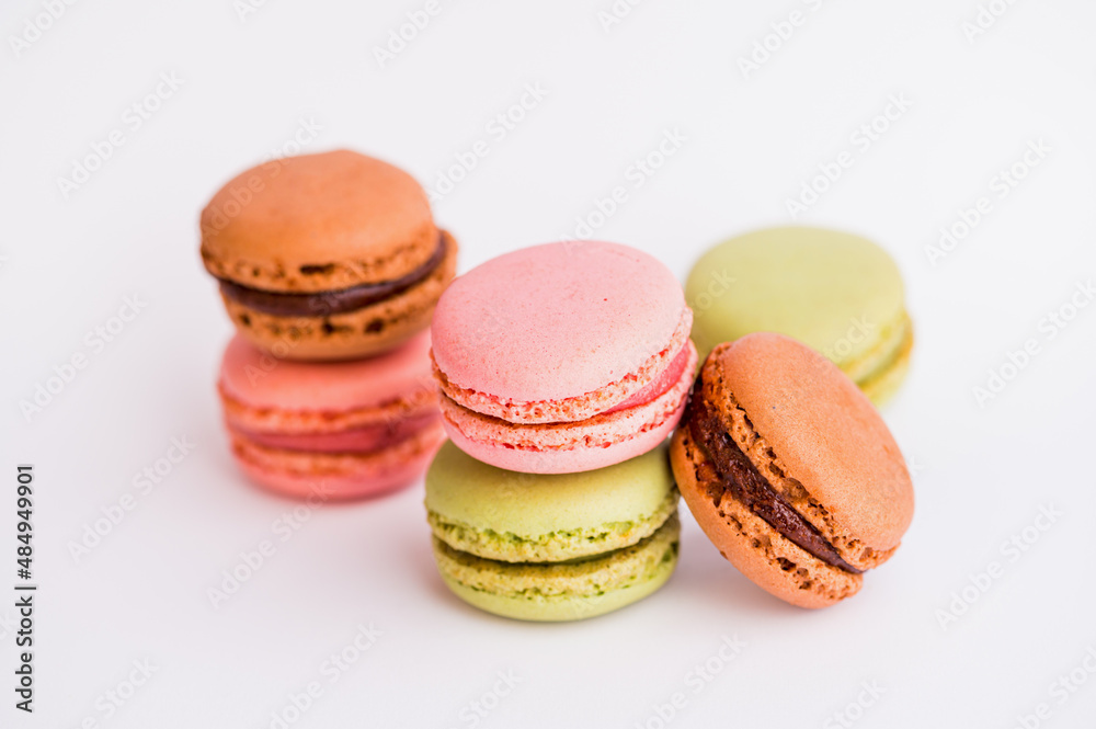 six macaroons in pink, green and brown against white background six macaroons in pink, green and brown against white background
