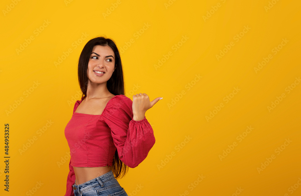 Check this. Positive armenian lady looking and pointing back at free space, indicating empty space for advertisement Check this. Positive armenian lady looking and pointing back at free space, indicating empty space for advertisement