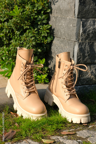 Beige trendy boots. Fashion female shoes still life. 